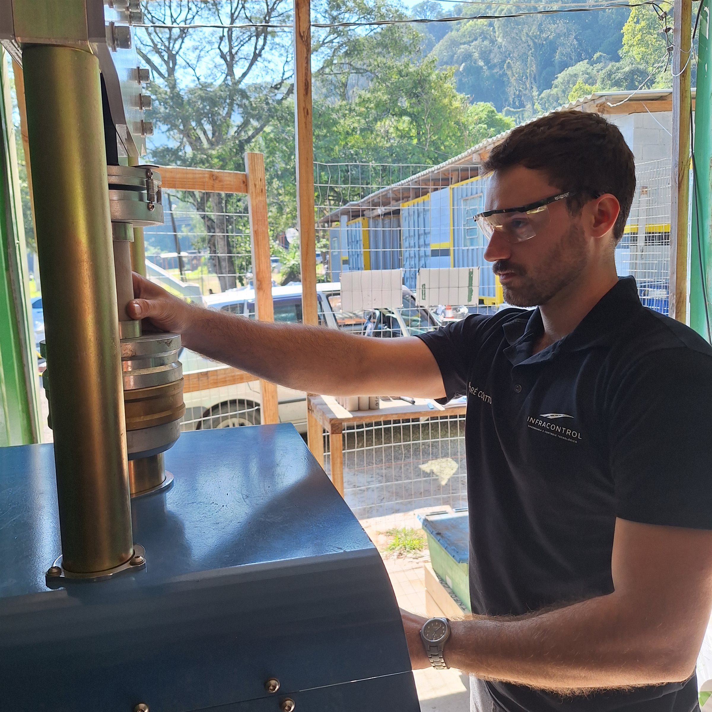 Engenheiro da Infracontrol operando a prensa em ensaio de resistência